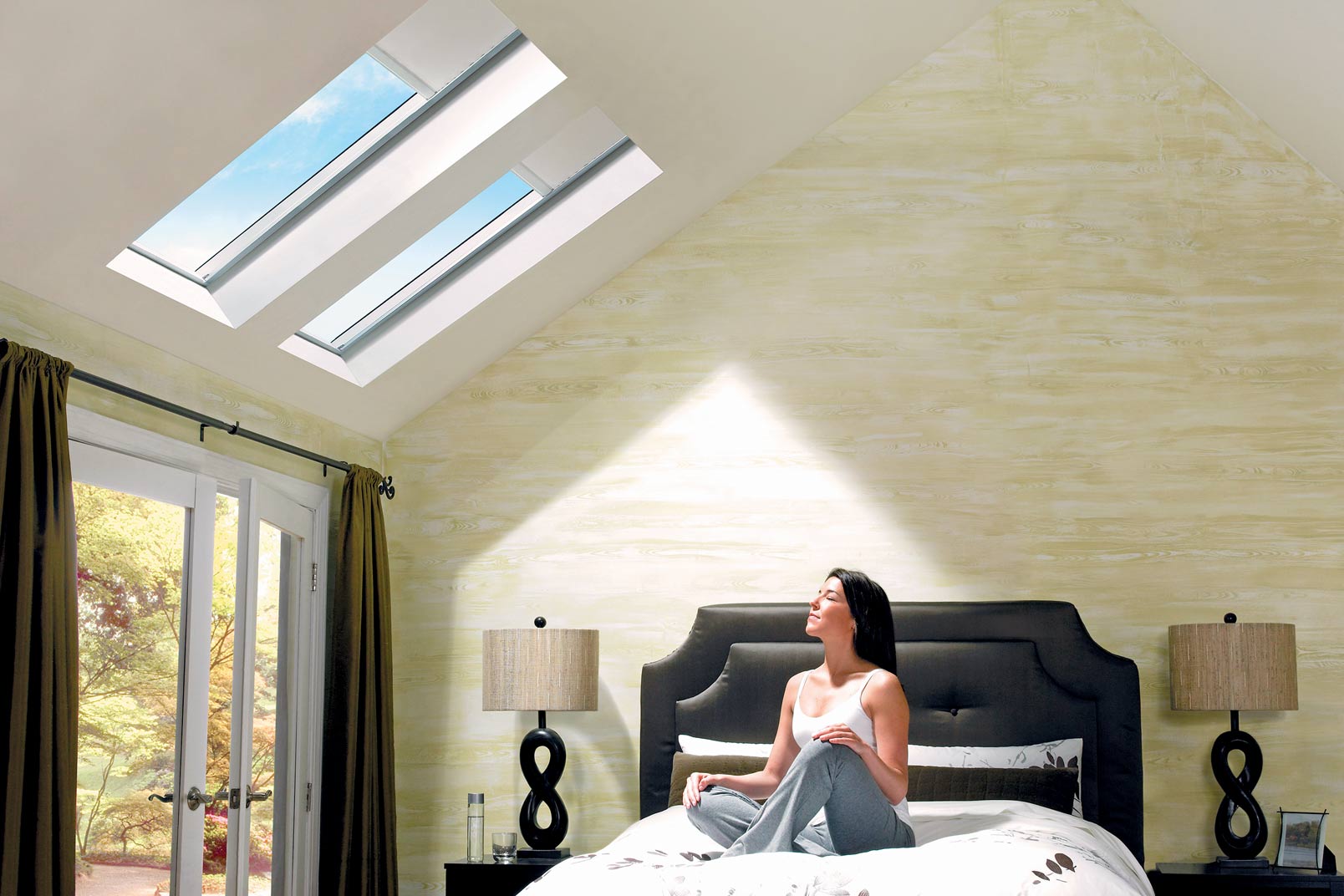 woman on bed admiring the natural daylight and skylights in wellington